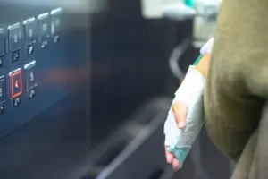 A person with an injured hand in an elevator.