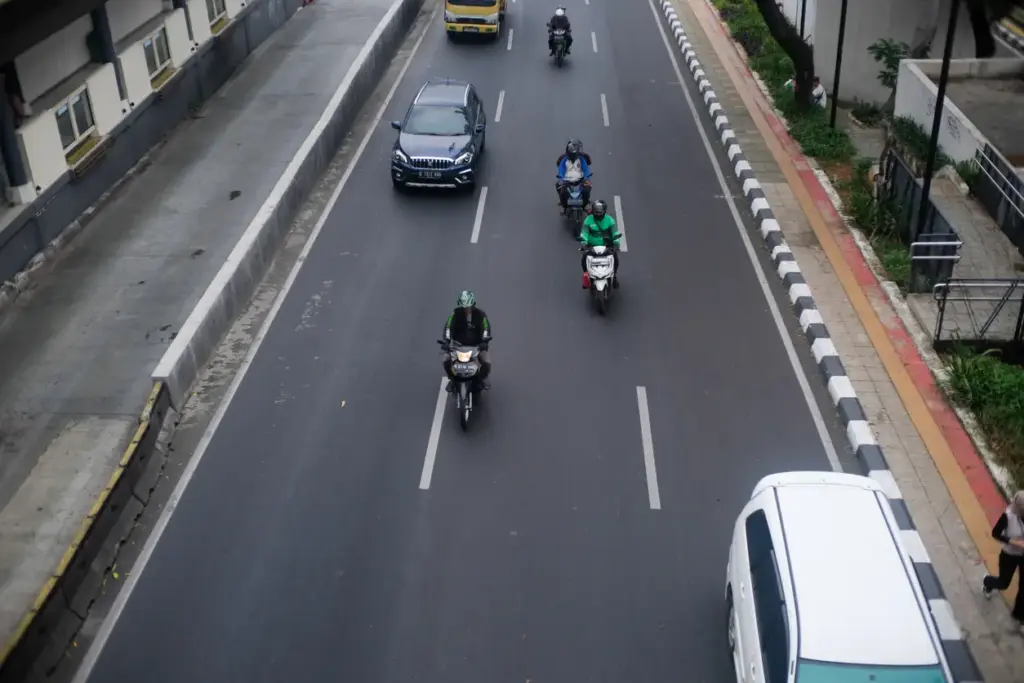 A group of motorcyclists changing lanes on the road.