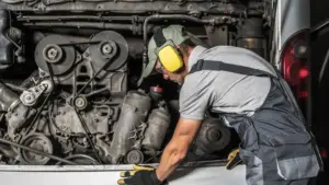 A mechanic examining a bus engine.