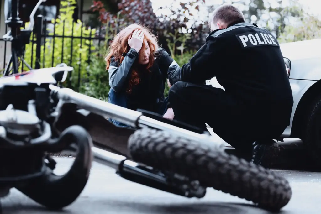 A police officer talking to an injured motorcyclist.