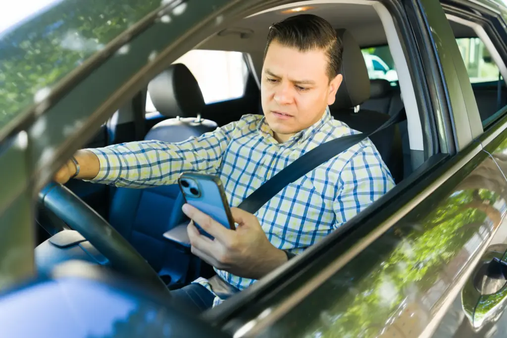 A rideshare driver looking at his phone.