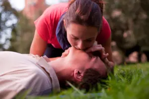 A woman performing CPR for an injured man. 