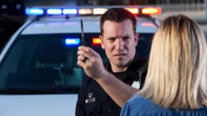 A police officer testing a woman to see if she is drunk.  