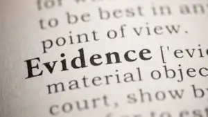 A closeup of the word 'Evidence' in a dictionary.