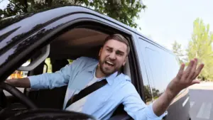 Un hombre enojado sacando la cabeza y el brazo con ira.