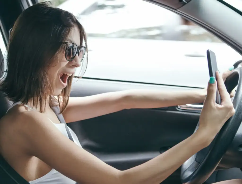 A woman taking a selfie while driving.