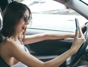 Una mujer tomándose una selfie mientras conduce.