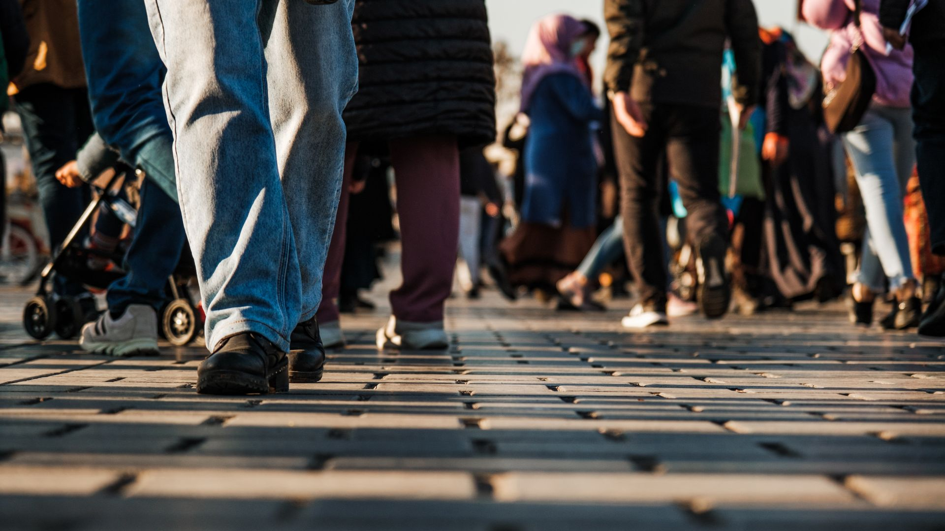 A close up of people walking on a sidewalk,