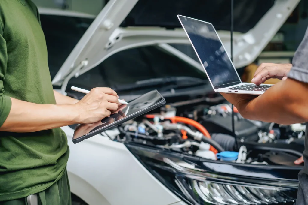Dos personas dando servicio a un auto autónomo.