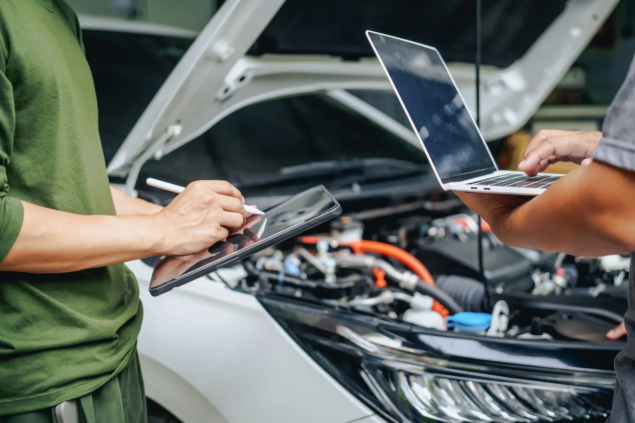Dos personas dando mantenimiento a un automóvil autónomo.
