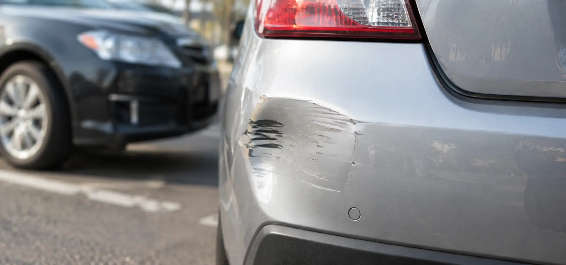 A dent in a car's rear bumper.
