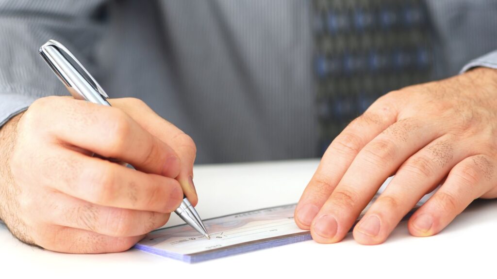 Attorney writing out a check for their client.