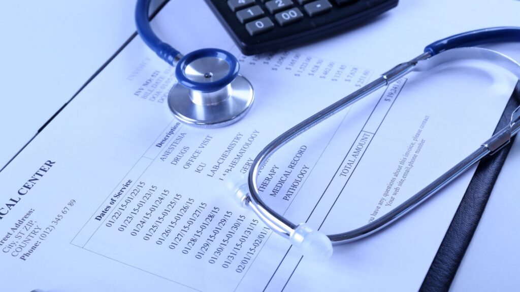 Medical form with stethoscope and calculator on top of it.