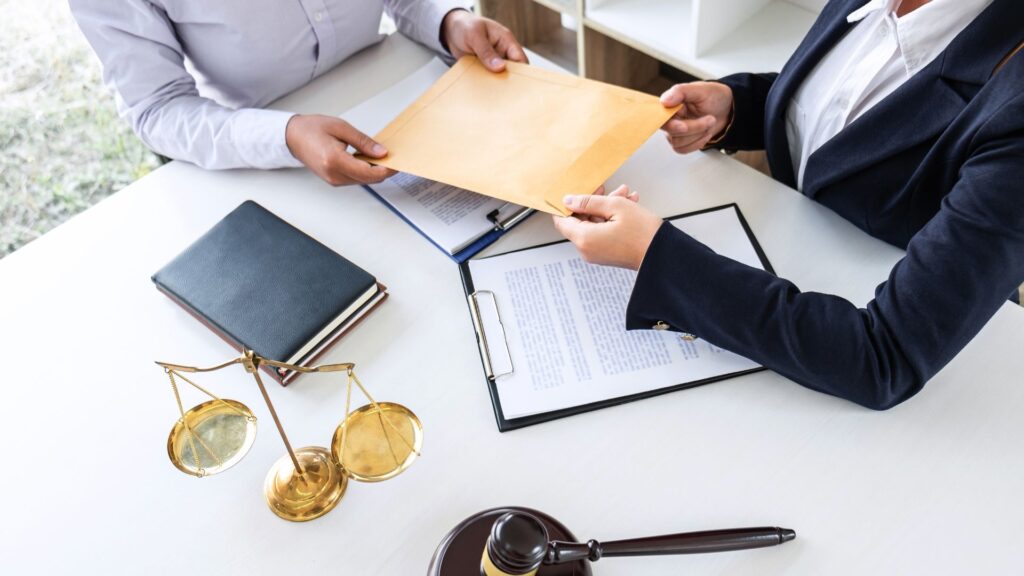 Two women at a law office desk preparing to file a lawsuit.