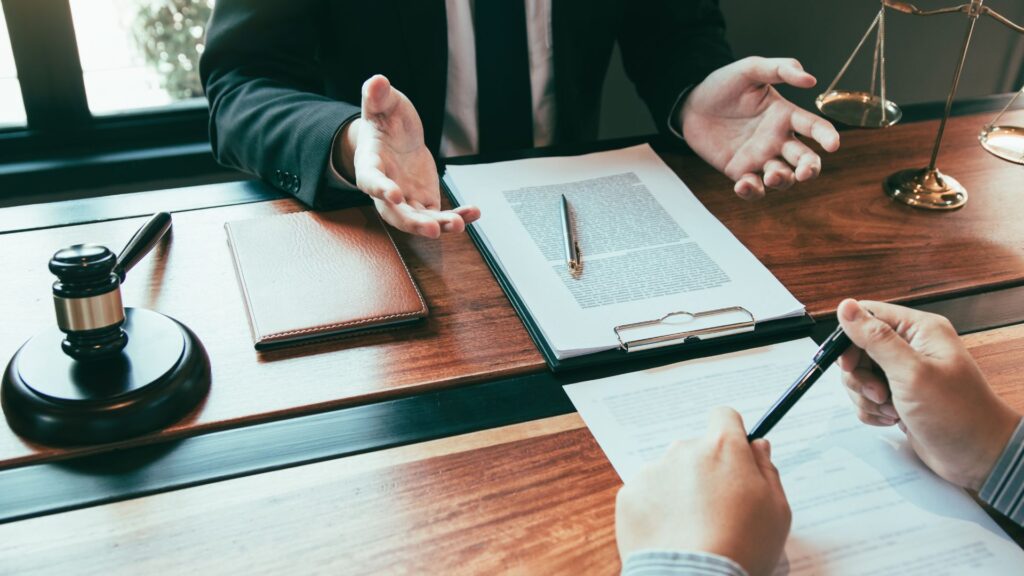 Attorney at his desk meeting with his client and going over legal documents.