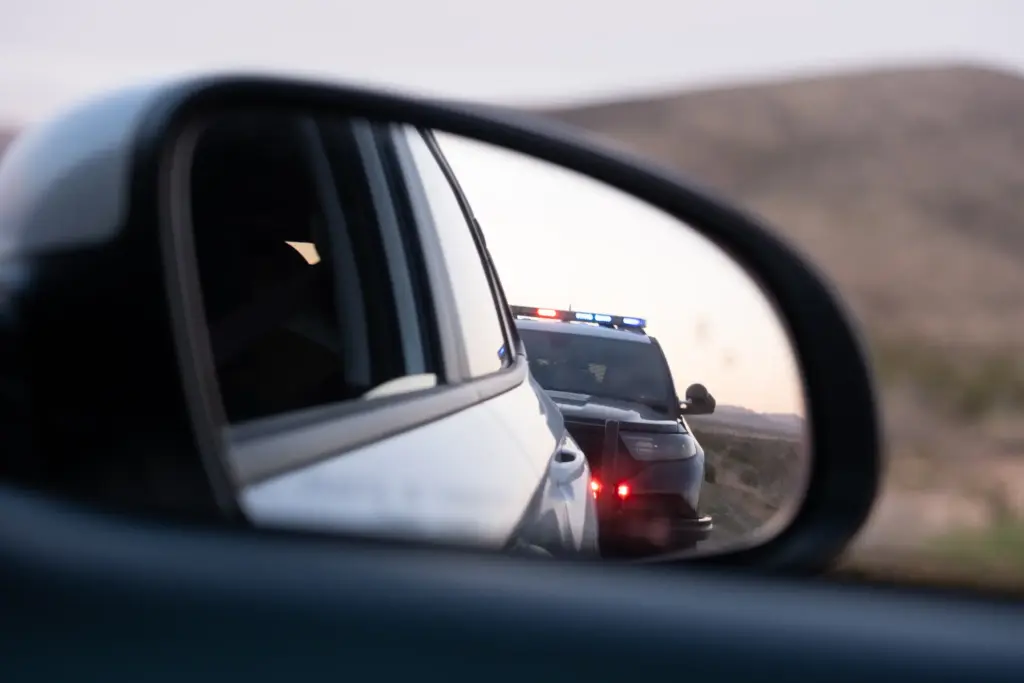 A car getting pulled over by a police car.