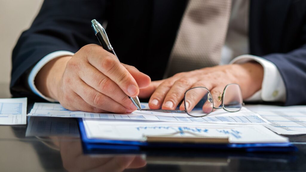 Abogado de lesiones personales firmando un cheque para su cliente.