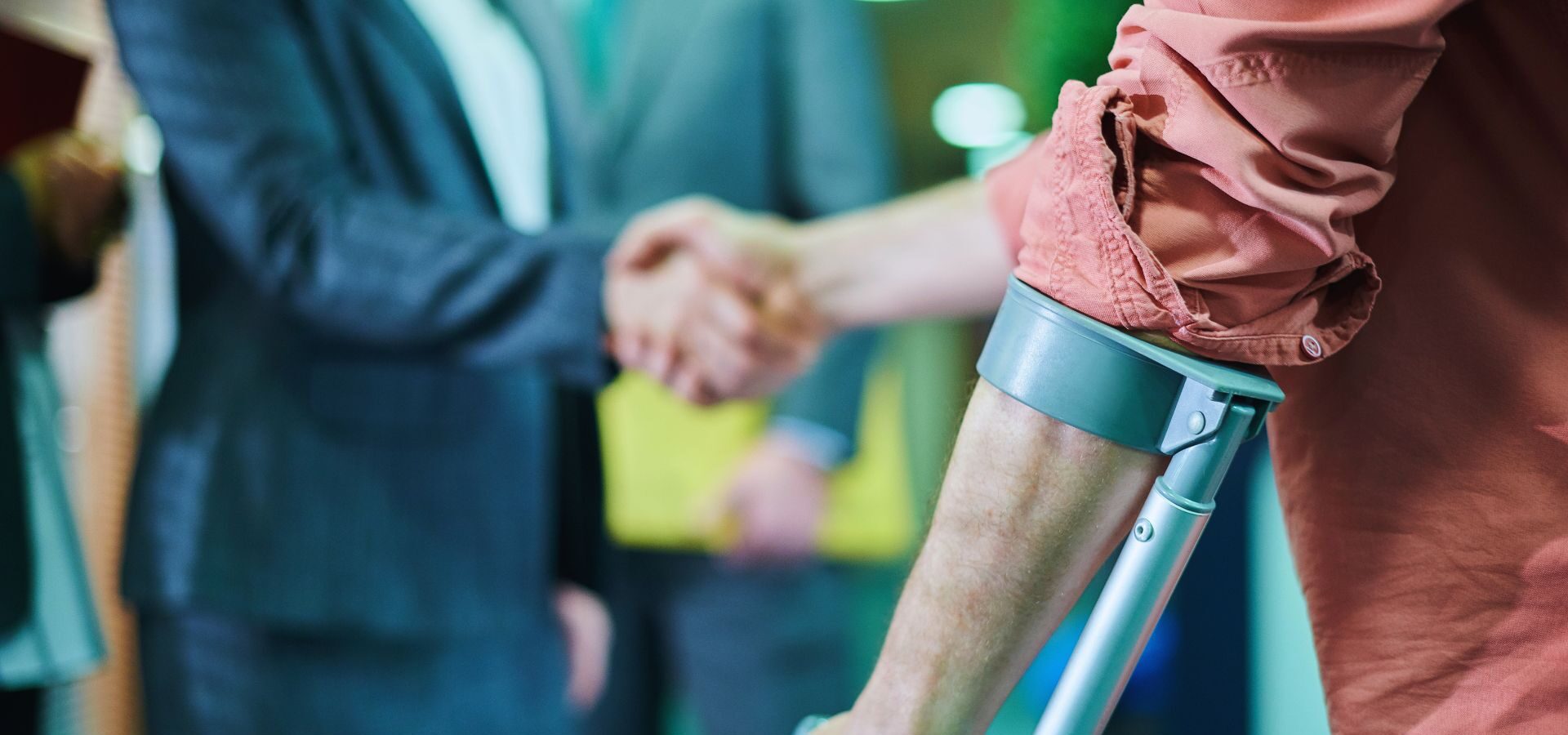 Injured man in crutches shaking hands with a personal injury attorney.