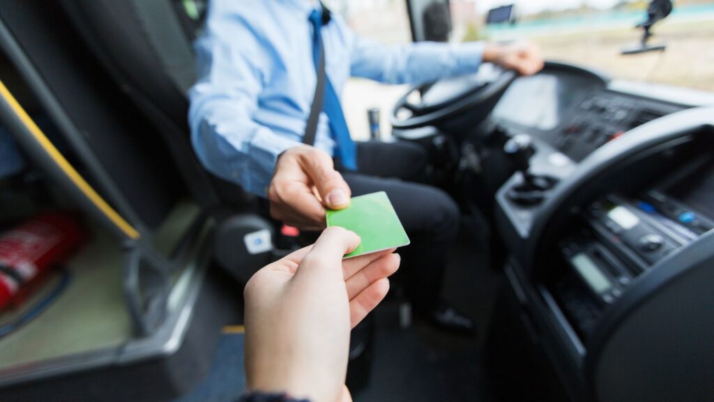 Bus driver taking a bus card from a passenger