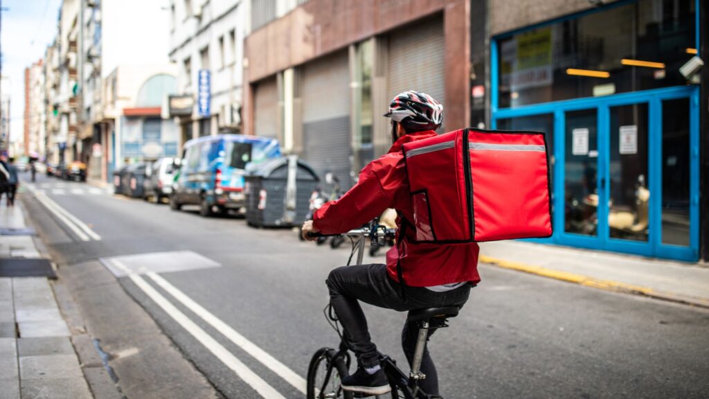 A man delivering food on a bike.