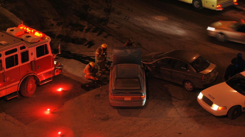 Escena de accidente de carro en una carretera por noche.