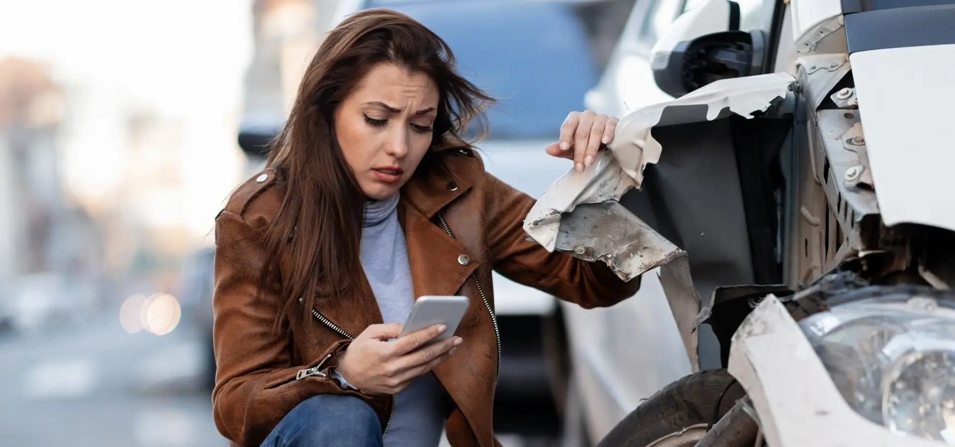A woman calling someone after getting involved in a car crash.