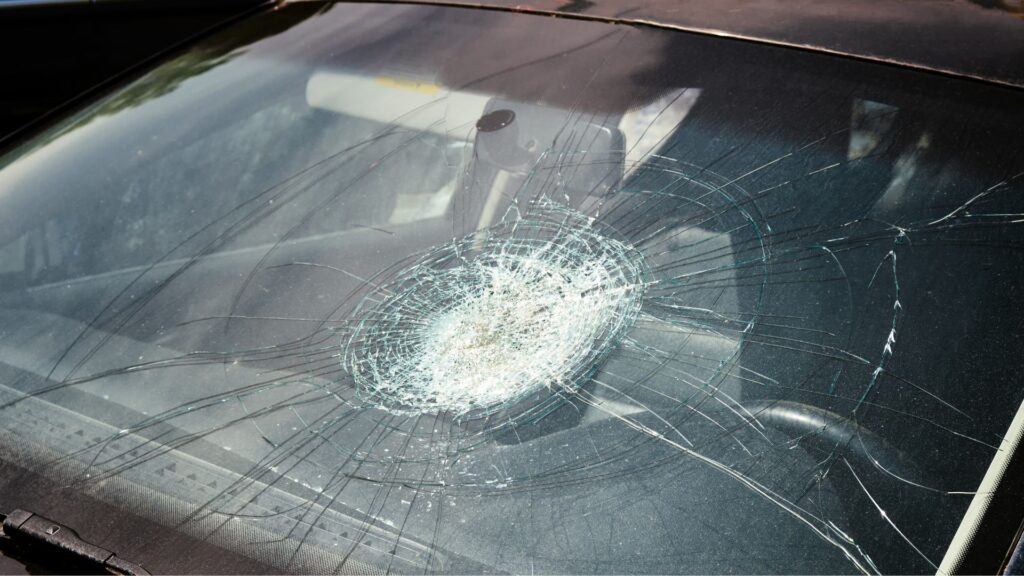 A car with a large crack on its windshield.