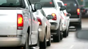 A row of cars with their brake lights on.