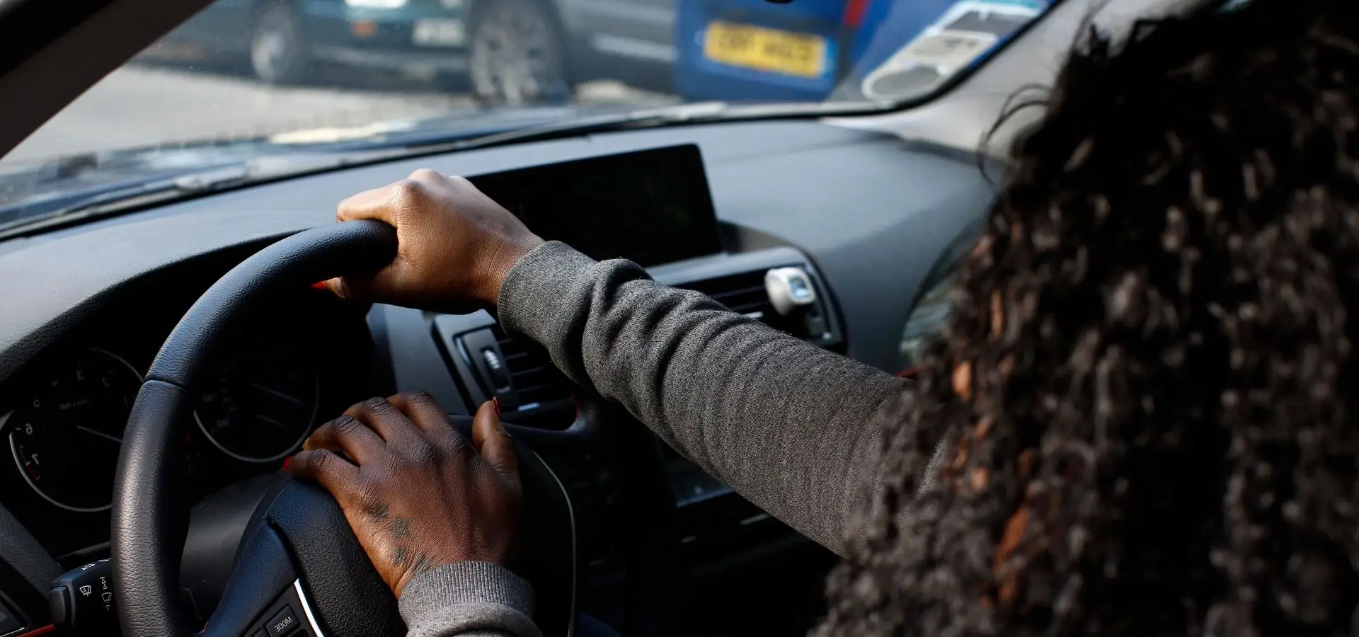 A woman honking her horn at someone.
