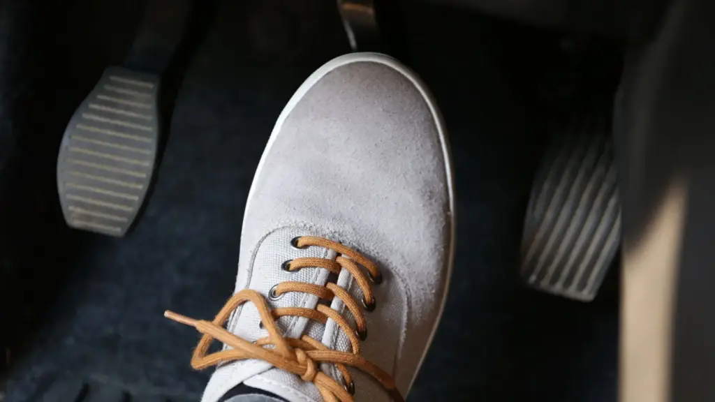 A person putting their foot over a car's brakes.