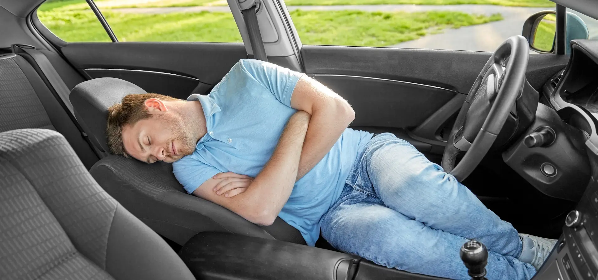 A man sleeping in his car.