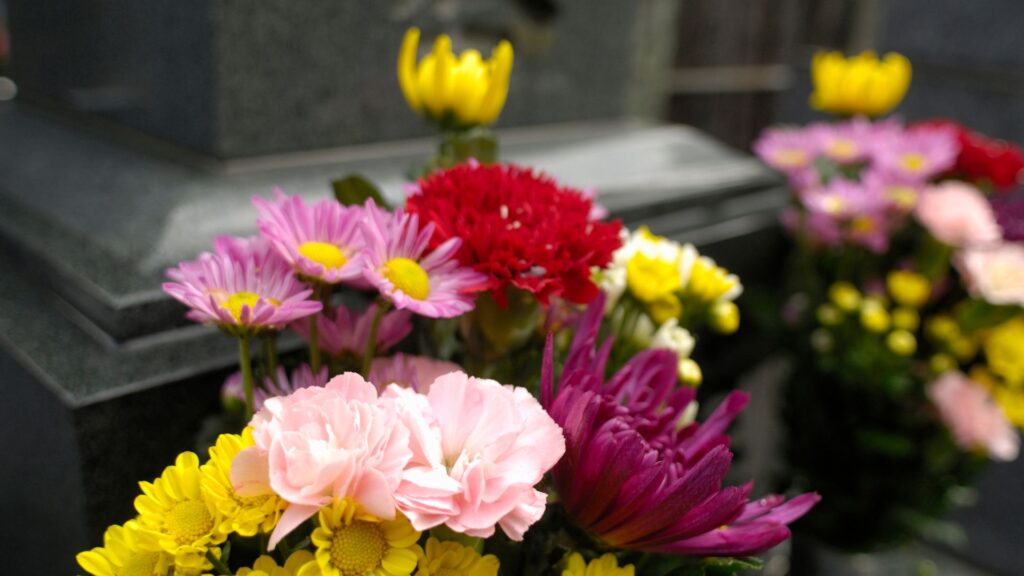 A colorful bouquet of flowers in front of a coffin.