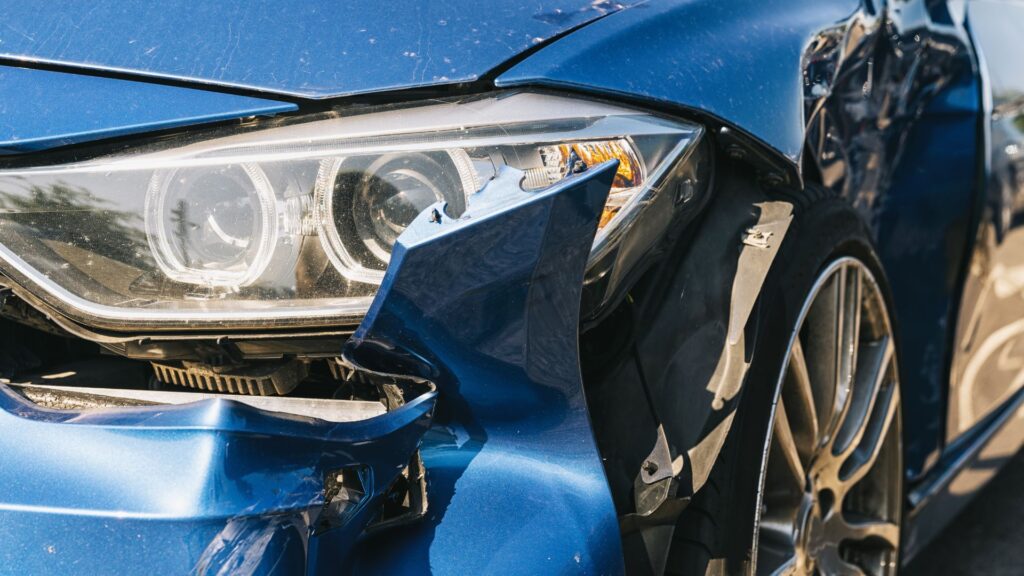 Una toma cercana de un carro azul chocado.