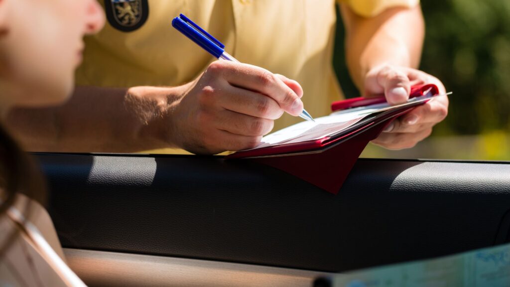 A police officer issuing a ticket to a driver.