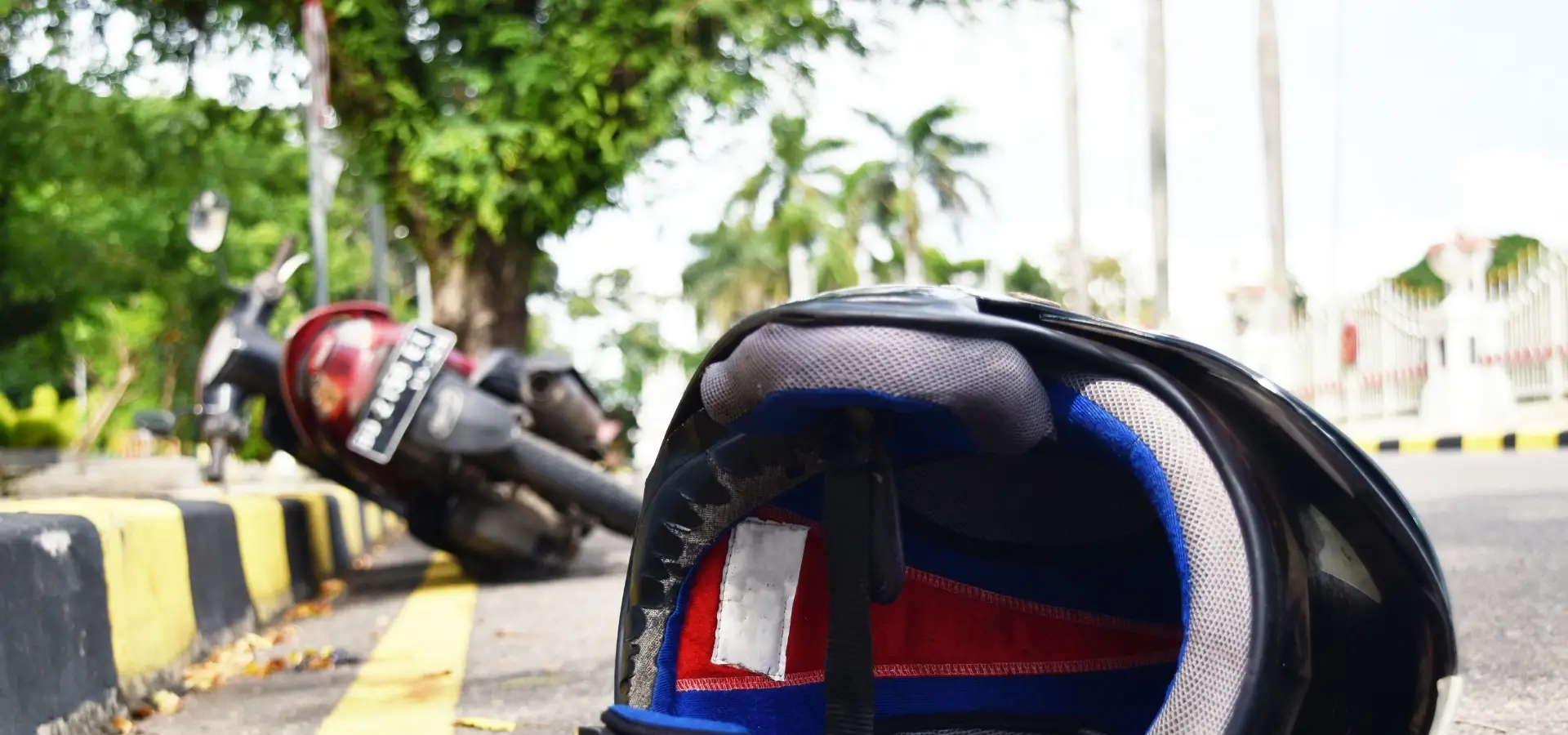 A tilted over motorcycle and a motorcycle helmet on the street indicating an accident.