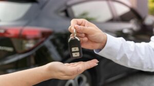 A person handing off car keys to another person.