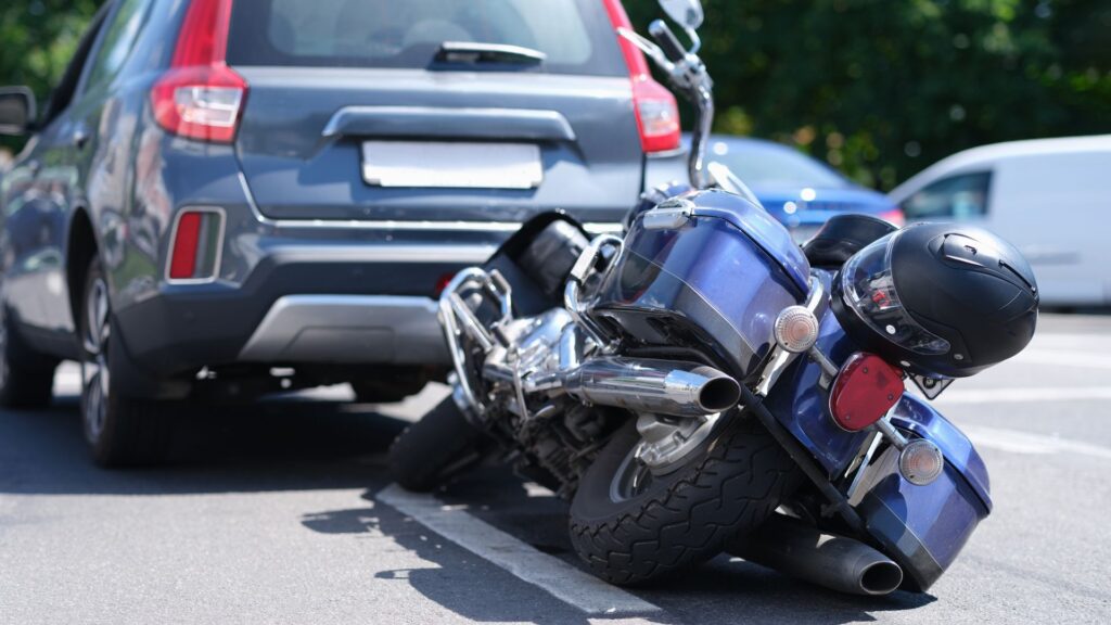A blue motorcycle rear ending a car.