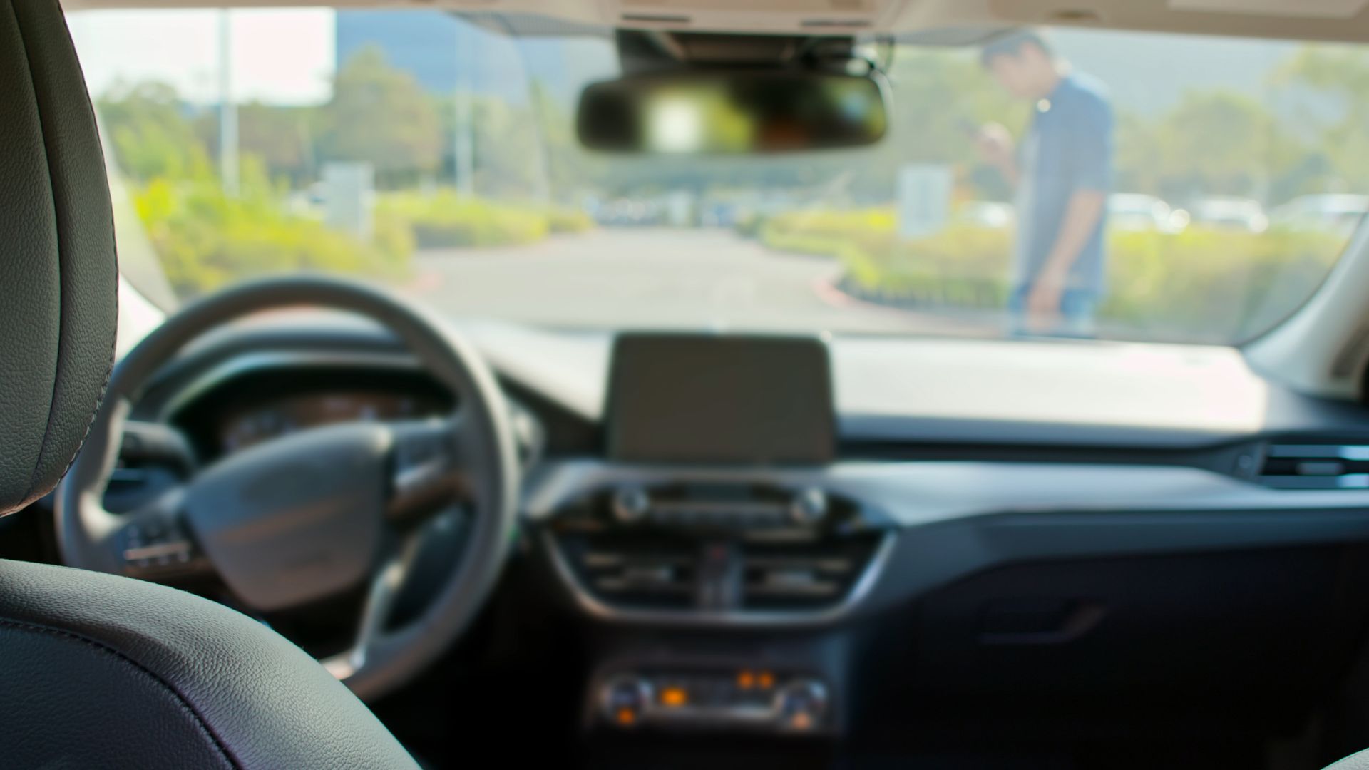 A self-driving car about to hit a pedestrian who is looking down on their phone.