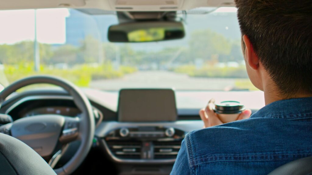 Una persona sentada en el asiento del pasajero de un coche autónomo.