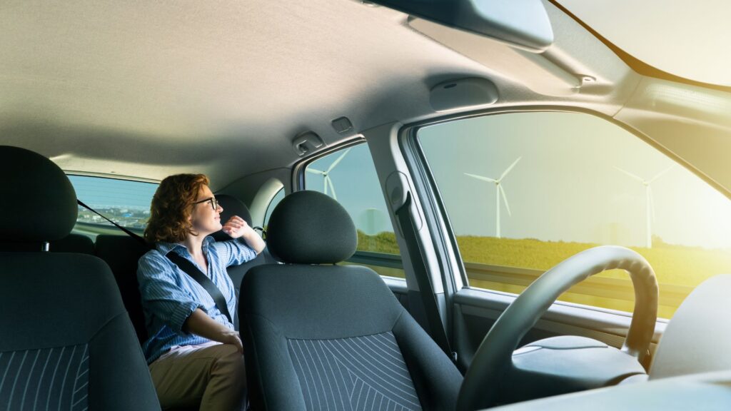 A person sitting in the backseat of a self-driving car.