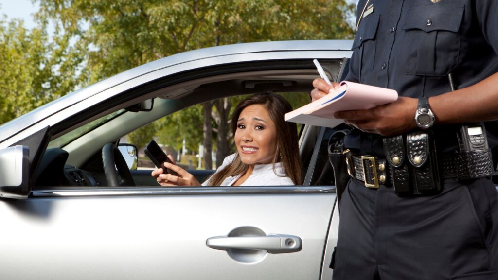 A woman getting a ticket from a police officer.