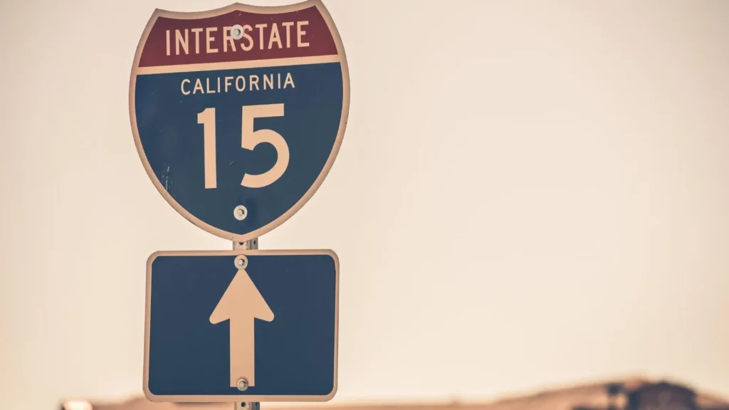 A sign of Interstate 15 on a road.