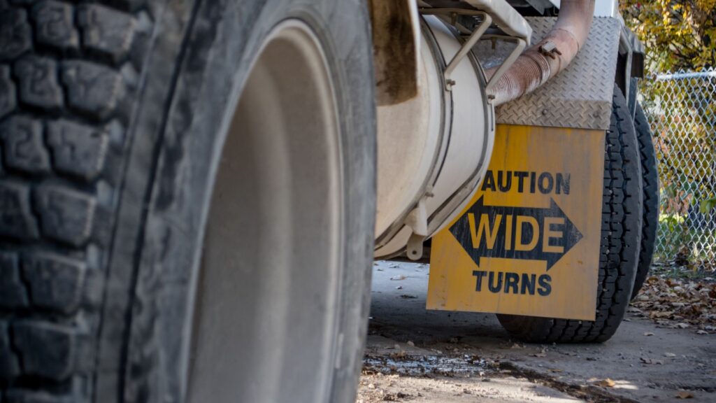 A large truck's undercarriage showcasing the wheels and the mud flap.