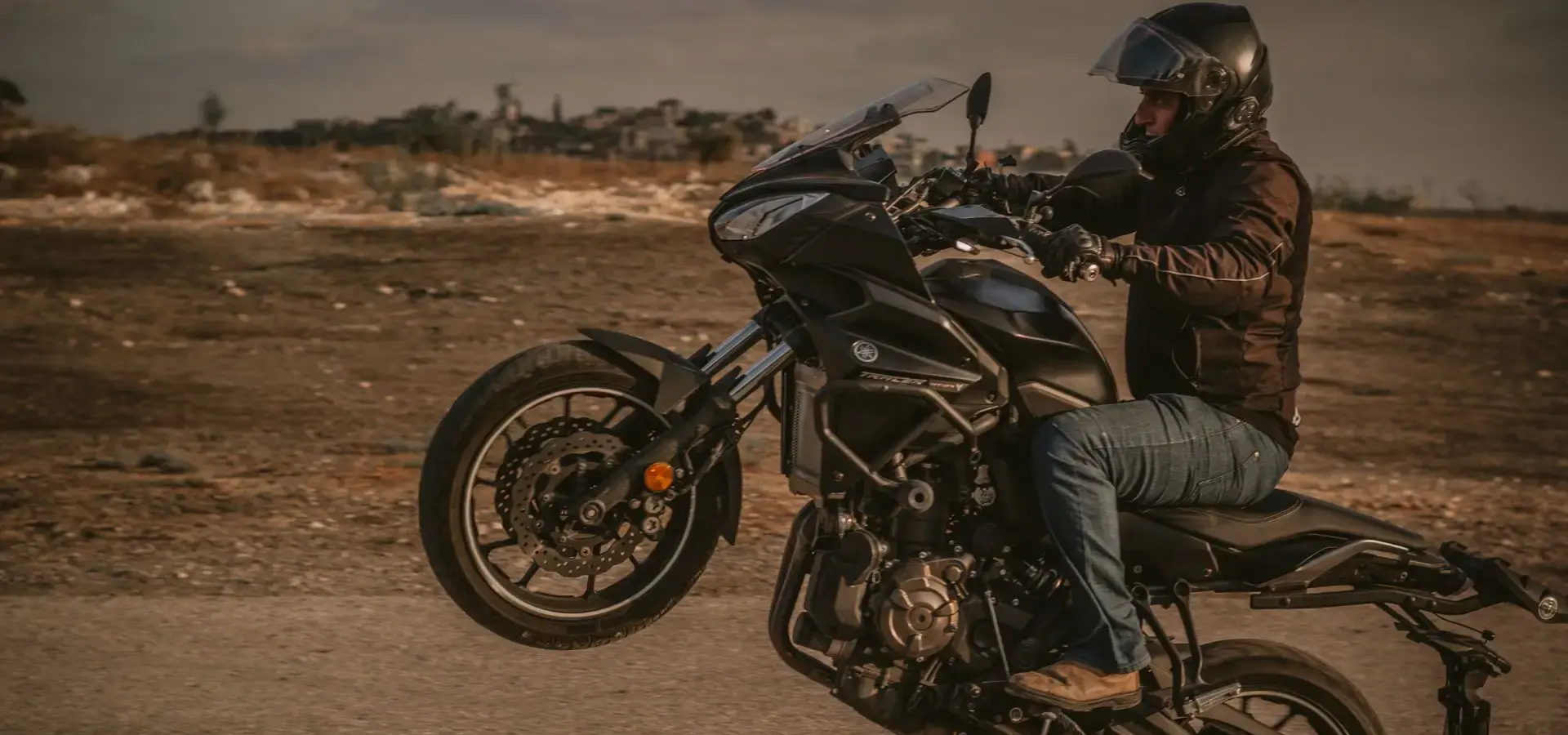 A man on a motorcycle doing a wheelie.