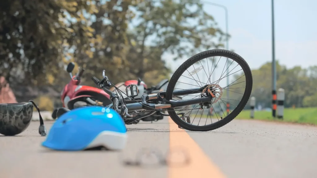 A blue helmet and a red bike on the middle of a road.