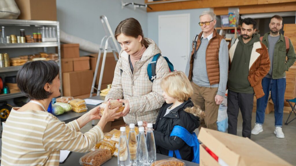A girl and her younger brother getting food from a disaster relief shelter.