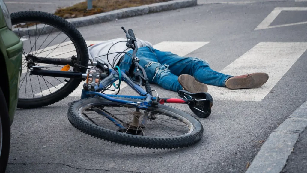 A biker on the ground after an accident has occurred.