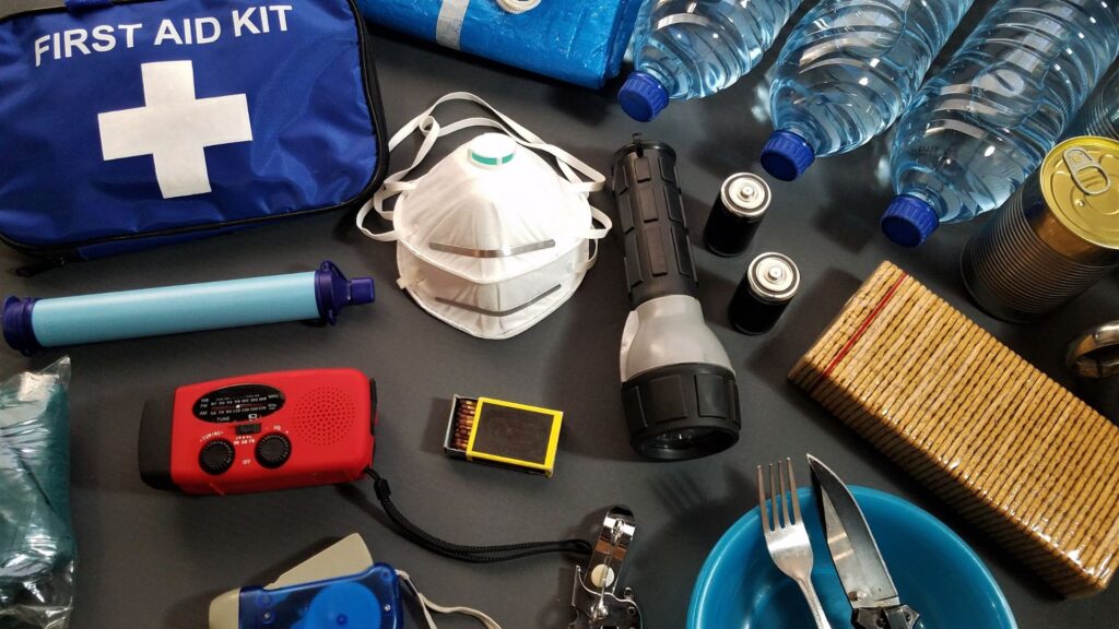 An emergency preparation kit with a variety of items spread out on a table.