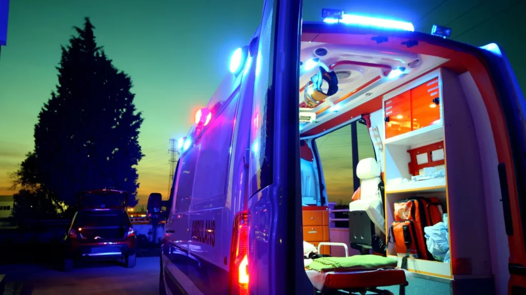 An ambulance with the back door open with the sun setting in the background.