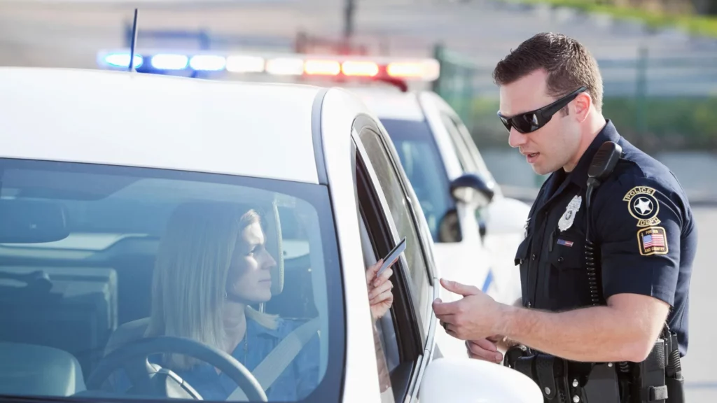 A police officer getting a woman's driver's license after pulling her over.
